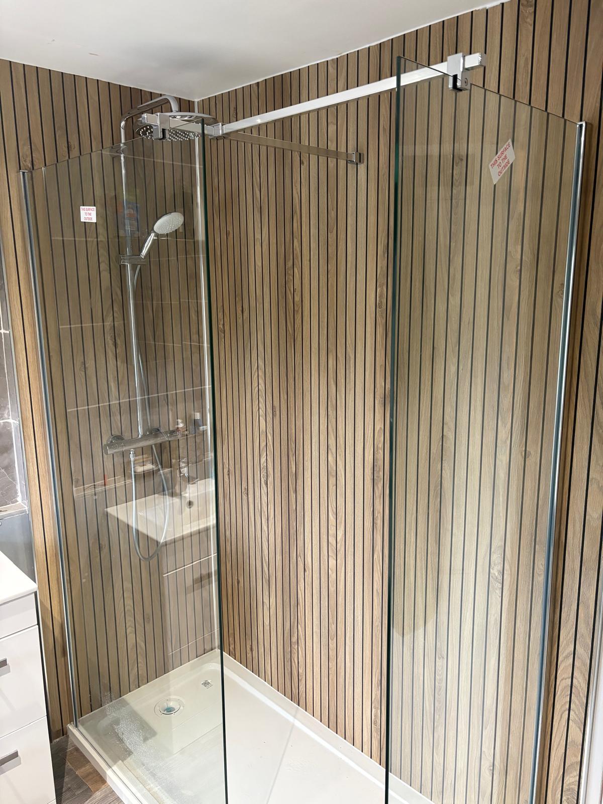Walk-in shower with oak slat panelled walls and chrome fittings